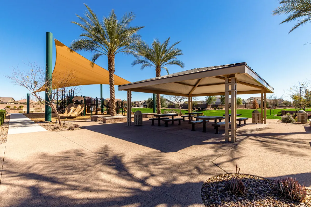 A vibrant community playground with modern equipment, shaded seating, and swaying palm trees. Families and children can be envisioned enjoying the space, fostering a sense of joy and togetherness.